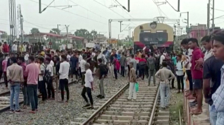 Demonstrators block a train as they protest against "Agnipath scheme" for recruiting personnel for armed forces, in Jehanabad, Bihar, India June 16, 2022 in this still image obtained from a handout video. ANI/Handout via REUTERS  