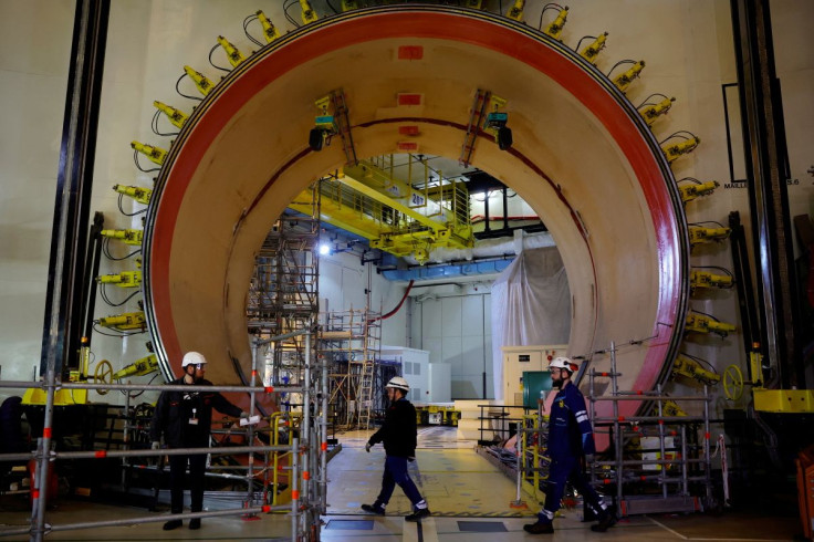Workers walk past the material entrance inside the reactor building on the construction site of the third-generation European Pressurised Water nuclear reactor (EPR) in Flamanville, France, June 14, 2022. 