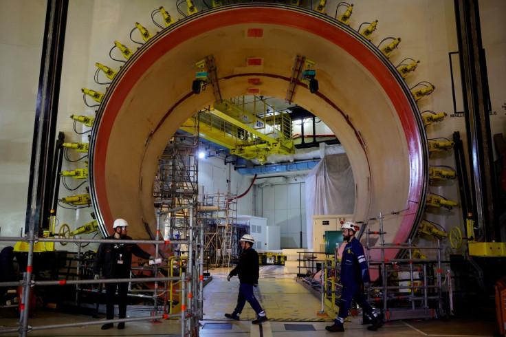 Workers walk past the material entrance inside the reactor building on the construction site of the third-generation European Pressurised Water nuclear reactor (EPR) in Flamanville, France, June 14, 2022.
