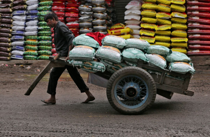 A labourer pulls a handcart loaded with sacks of lentils at a grain market in Ahmedabad, India, July 12, 2018.