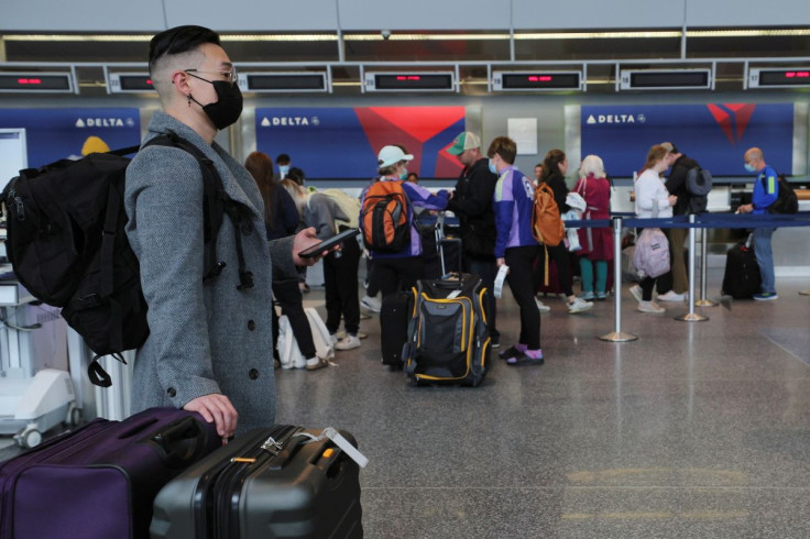 A traveller wearing a mask waits near the Delta Airlines counters, after a federal judge in Florida struck down the CDC's public transportation masking order due to the coronavirus disease (COVID-19) prevention efforts, at Logan International Airport in B
