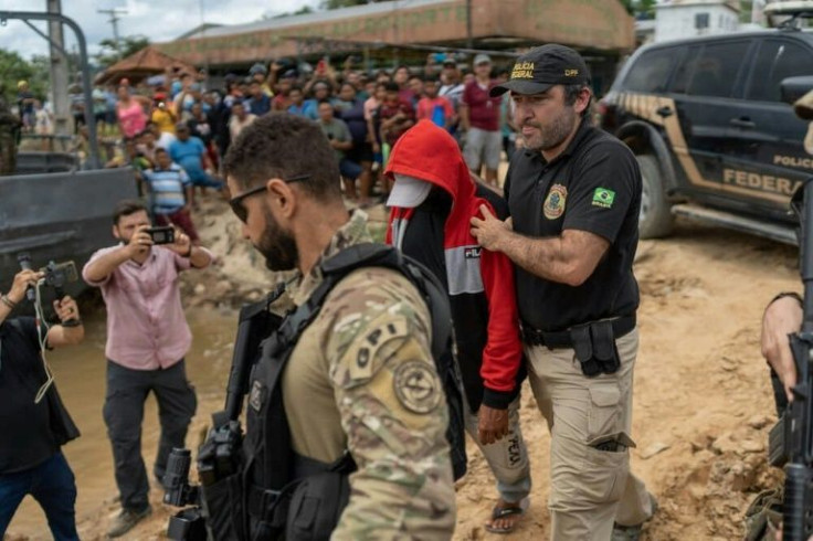Federal police officers escort suspect Amarildo da Costa de Oliveira onto a boat in Atalaia do Norte, Brazil, on June 15, 2022