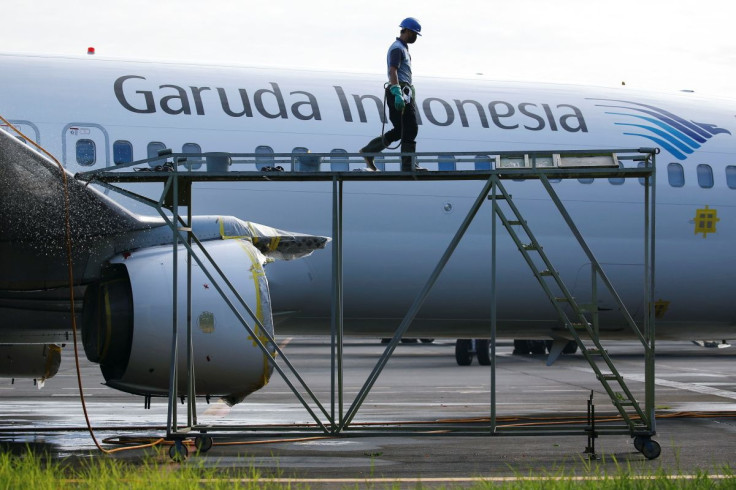 A worker walks on a crane as a Garuda Indonesia's aircraft is parked at the Garuda Maintenance Facility (GMF) AeroAsia, at Soekarno-Hatta International airport near Jakarta, Indonesia, January 21, 2022.