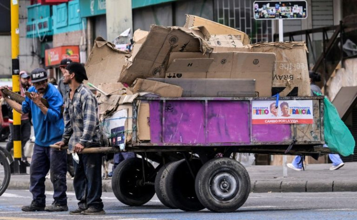 Recyclers pull a cart displaying ads by Colombian left-wing presidential candidate Gustavo Petro and his running mate Francia Marquez, in Bogota on June 16, 2022