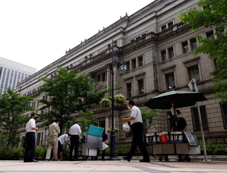 People buy their lunches from street vendors in front of the headquarters of Bank of Japan in Tokyo, Japan, June 17, 2022. 
