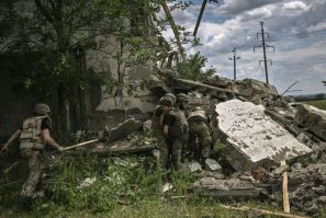 Ukrainian soldiers inspect a destroyed warehouse reportedly targeted by Russian troops on outskirts of eastern Lysychansk