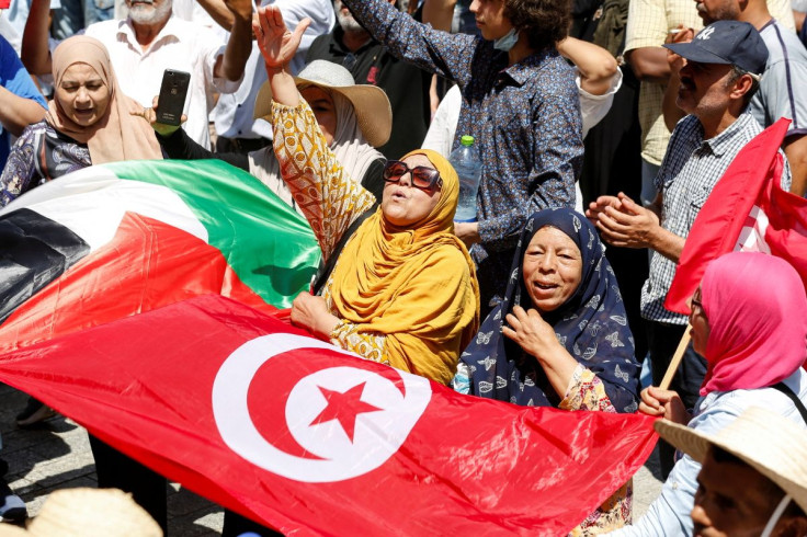 Demonstrators shout slogans as they display a Tunisian national flag during a protest against Tunisian President Kais Saied in Tunis, Tunisia June 19, 2022. 