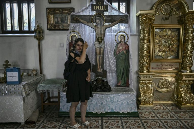 A woman wipes away tears as she attends a Sunday prayer at a church in Kramatorsk