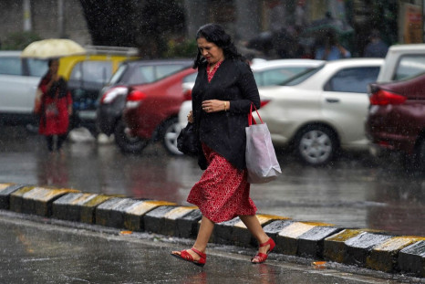A woman crosses a road as it rains in Mumbai, India, September 20, 2019. 