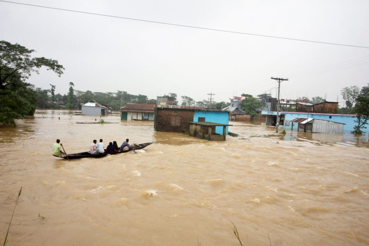 People move a boat in a flooded area during a widespread flood in the northeastern part of the country, in Sylhet, Bangladesh, June 19, 2022. 