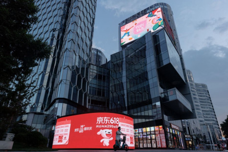 A person rides a scooter past a JD.com advertisement for the "618" shopping festival in a shopping district in Beijing, China June 14, 2022.  