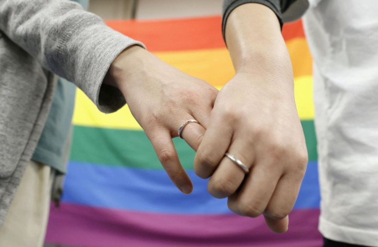 Plaintiffs hold hands each other after a district court ruled on the legality of same-sex marriages outside Sapporo district court in Sapporo, Hokkaido, northern Japan March 17, 2021, in this photo taken by Kyodo. 