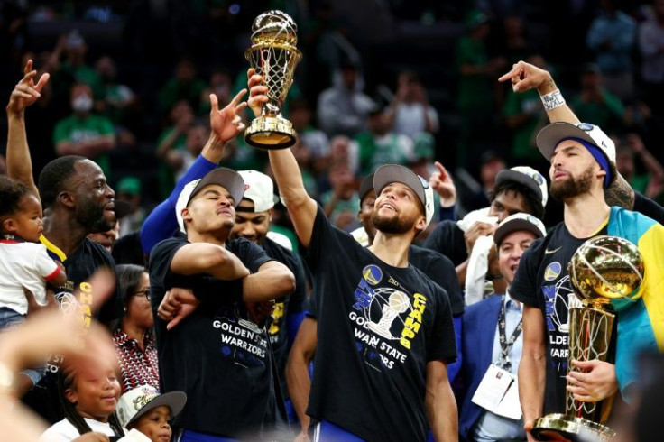 Star guard Stephen Curry of the Golden State Warriors raises the Bill Russell NBA Finals Most Valuable Player Award after defeating the Boston Celtics 103-90 in Game Six of the 2022 NBA Finals