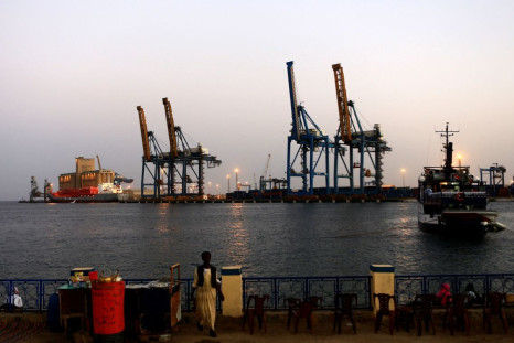 A man stands opposite the modern port at the harbour in Port Sudan at Red Sea State February 24, 2014. 