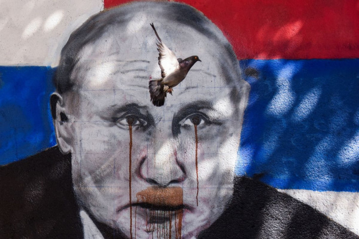 The pigeon flies over the mural of Russian President Vladimir Putin, which has been vandalised with red spray paint, following Russia's invasion of Ukraine, in Belgrade, Serbia, June 20, 2022. 