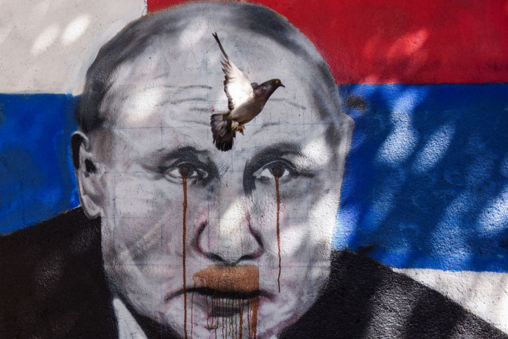 The pigeon flies over the mural of Russian President Vladimir Putin, which has been vandalised with red spray paint, following Russia's invasion of Ukraine, in Belgrade, Serbia, June 20, 2022.