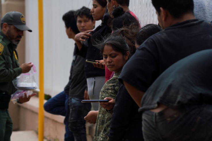 Migrants who recently crossed the border and were caught wait for instructions before they are escorted to Mexico after being dropped off by border patrol agents in Laredo, Texas, U.S. June 15, 2022. Picture taken June 15, 2022.