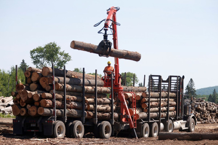 A worker unloads logs at the Murray Brothers Lumber Company in Madawaska, Ontario, Canada, July 4, 2018. 