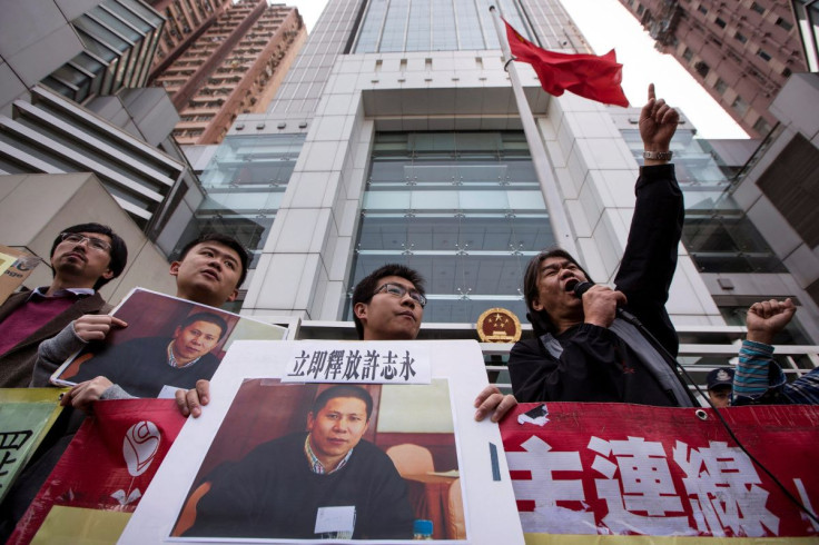 Protesters hold images of Chinese rights advocate Xu Zhiyong, during a demonstration calling for his release, outside the Chinese liaison office in Hong Kong, China January 27, 2014. Words above a picture of Xu read, "Release Xu Zhiyong immediately".