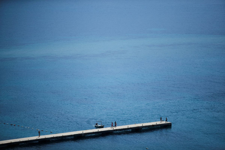 People walk on a pier in Budva, the main summer tourist destination in Montenegro, May 24, 2022. Picture taken May 24, 2022.