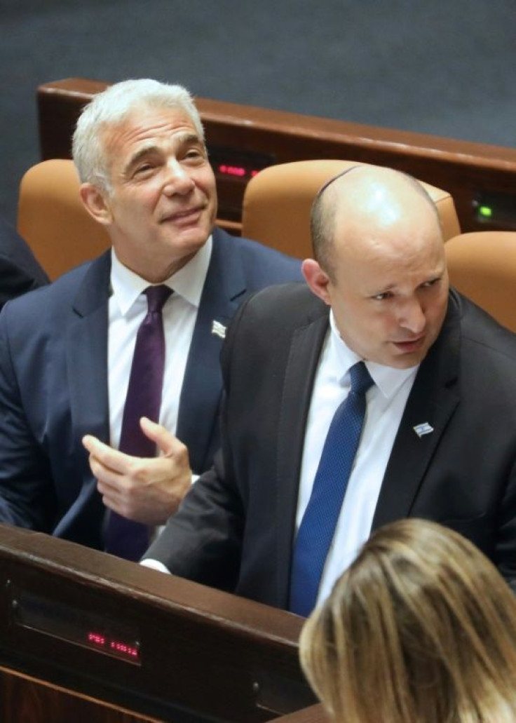 Israeli Foreign Minister Yair Lapid (L) and Prime Minister Naftali Bennett (R) attend the preliminary vote on a bill to dissolve parliament and call an early election