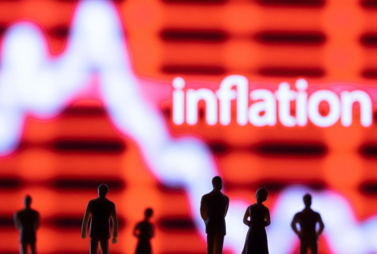 Figurines are seen in front of displayed stock graph and word "Inflation" in this illustration taken June 13, 2022. 