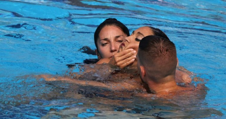 Team USA coach Andrea Fuentes (left) helps rescue unconscious artistic swimmer Anita Alvarez (centre)