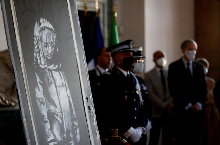 A mural by anonymous British street artist Banksy stolen from the Bataclan theatre in Paris and found in a farmhouse in central Italy is seen during the ceremony to return to France at the French embassy in Rome, Italy. July 14, 2020. 