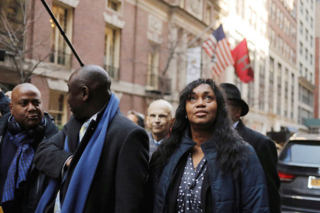 Tamara Lanier looks up as she walks with attorney Ben Crump (C) after speaking to the media about a lawsuit accusing Harvard University of the monetization of photographic images of her great-great-great grandfather, an enslaved African man named Renty, a