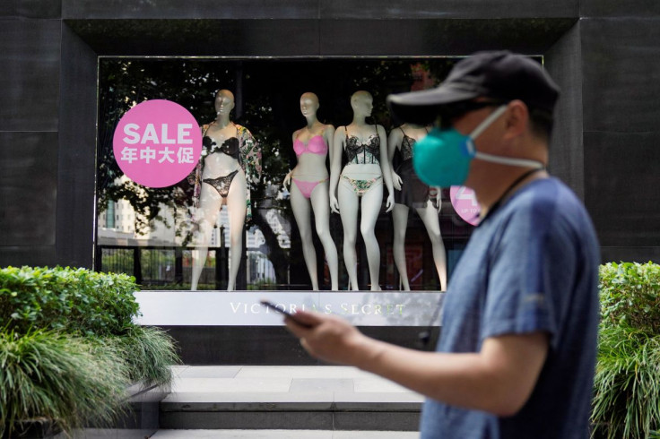 A man, wearing a face mask following the coronavirus disease (COVID-19) outbreak, walks past a sale sign on a display window of a Victoria's Secret store in Shanghai, China June 21, 2022.