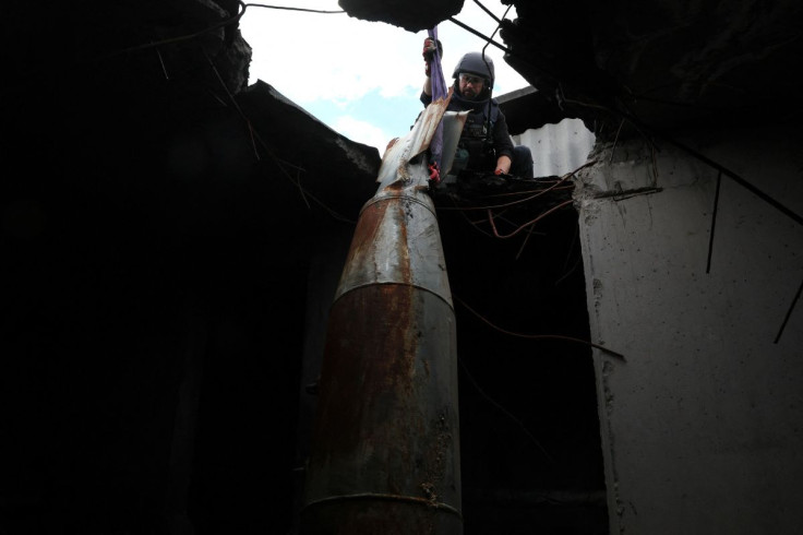 Members of a specialised team that defuses and removes explosives, bombs, mines and other munitions remove a defused 500kg bomb that did not detonate when it landed on an apartment building in March, in the Saltivka neighbourhood, as Russiaâs attack on 