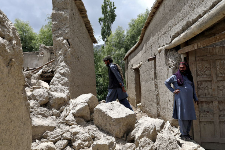 Afghan men stand on the debris of their house that was damaged by an earthquake in Gayan, Afghanistan, June 23, 2022. Picture taken June 23, 2022. 