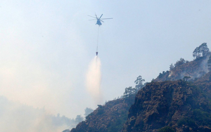 A firefighting helicopter drops water to extinguish a wildfire near Marmaris, a town in Mugla province, Turkey, June 23, 2022. 