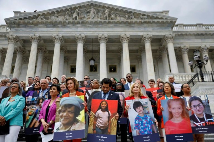 Speaker of the House Nancy Pelosi stands with fellow Democrats holding photographs of the victims of the mass shootings in Buffalo, New York and Uvalde, Texas, before passing the Bipartisan Safer Communities Act in front of the House of Representatives on