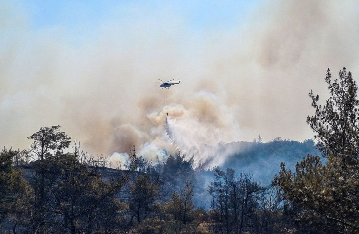 A firefighting helicopter drops water on a wildfire near Marmaris, a town in Mugla province, Turkey, June 22, 2022. 