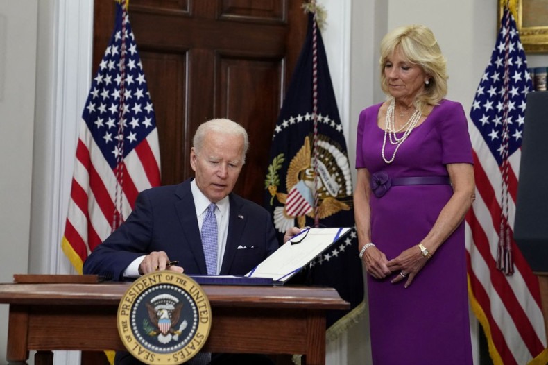 U.S. President Joe Biden signs S. 2938: Bipartisan Safer Communities Act into law from the Roosevelt Room at the White House as first lady Jill Biden stands next to him in Washington, U.S., June 25, 2022. 