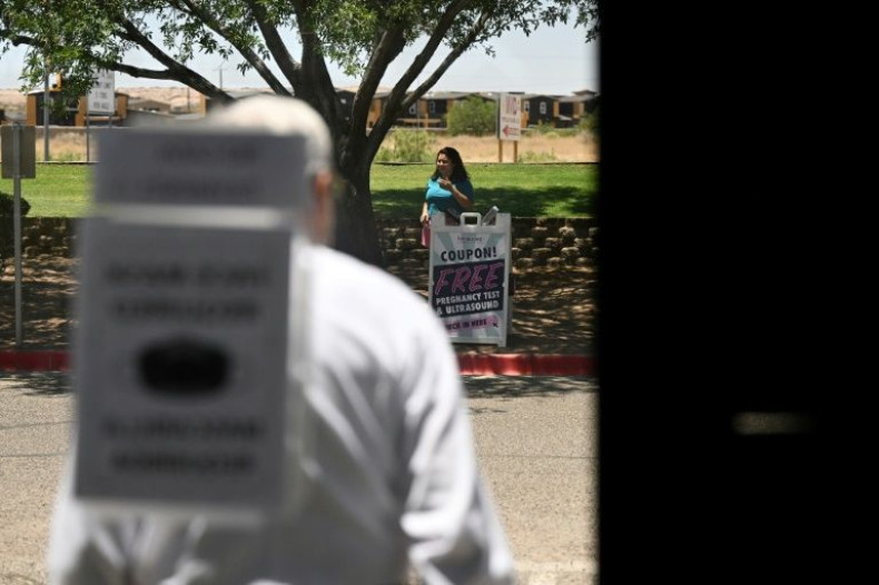 A worker from Her Care Connection offers free pregnancy and ultrasound tests in an attempt to convince women seeking an abortion to continue their pregnancy, outside the Women's Reproductive Clinic in Santa Teresa, New Mexico, on June 15, 2022