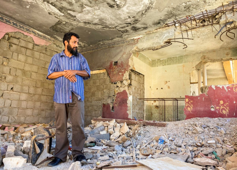 Badr Omar, an English teacher, stands in the ruins of his apartment in the 600 Block district of Libyaâs Sirte that was damaged by fighting, in Sirte, Libya, June 16, 2022. 