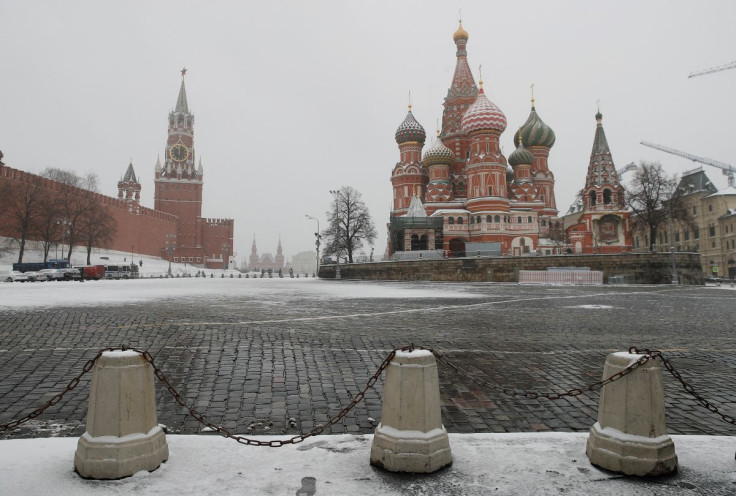 The clock on Spasskaya tower showing the time at noon, is pictured next to Moscow?s Kremlin, and St. Basil?s Cathedral, March 31, 2020. 