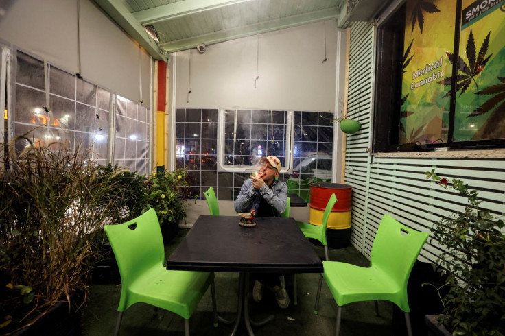 A worker smokes a joint at a medical cannabis cafe in Tira, an Arab village in central Israel March 2, 2022.  