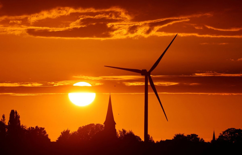 A power-generating windmill turbine and the church of the village are pictured during sunset at a wind park in Ecoust-Saint-Mein, France, September 6, 2020. 