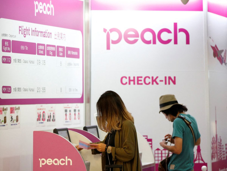 Passengers use Peach Aviation's check-in machines at New Tokyo international airport in Narita, east of Tokyo, July 7, 2014. 