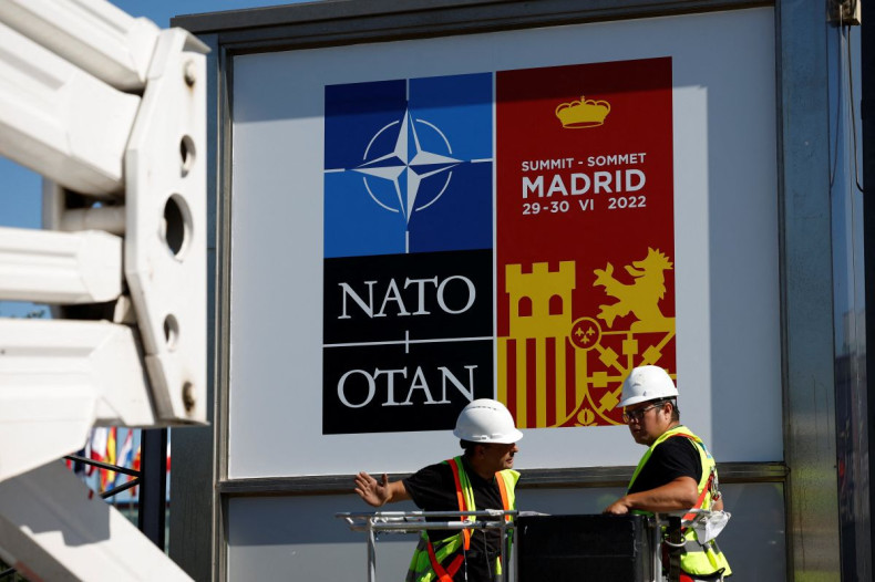 Workers paste the posters announcing the NATO Summit outside the Madrid Fair before a NATO summit in Madrid, Spain June 27, 2022. 