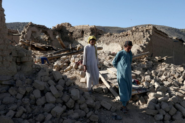 Afghan people walk through the debris of damaged houses after the recent earthquake in Wor Kali village in the Barmal district of Paktika province, Afghanistan, June 25, 2022.