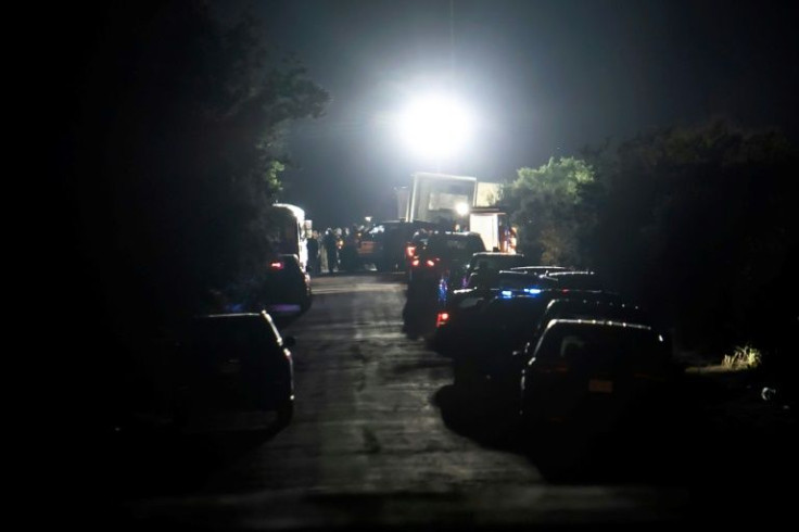 Emergency vehicles are seen at the scene where a tractor-trailer containing dozens of dead migrants was discovered in San Antonio, Texas on June 27, 2022