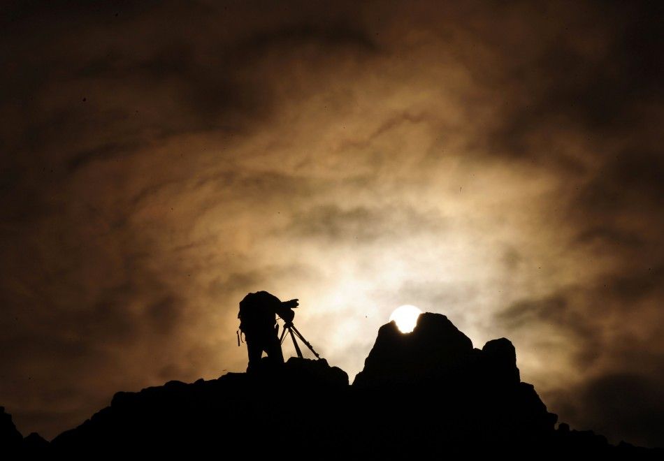 A man uses a camera on a rocky crest filled with astronomical markers during the summer solstice at the Kokino megalithic observatory June 21, 2010. The 3,800-year-old observatory was discovered in 2001 in the northwestern town of Kumanovo, 70 km 43 mile