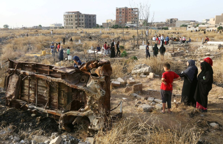 People visit the graves of their loved ones during the first day of the Muslim holiday of Eid al-Fitr in Raqqa, Syria, June 5, 2019.
