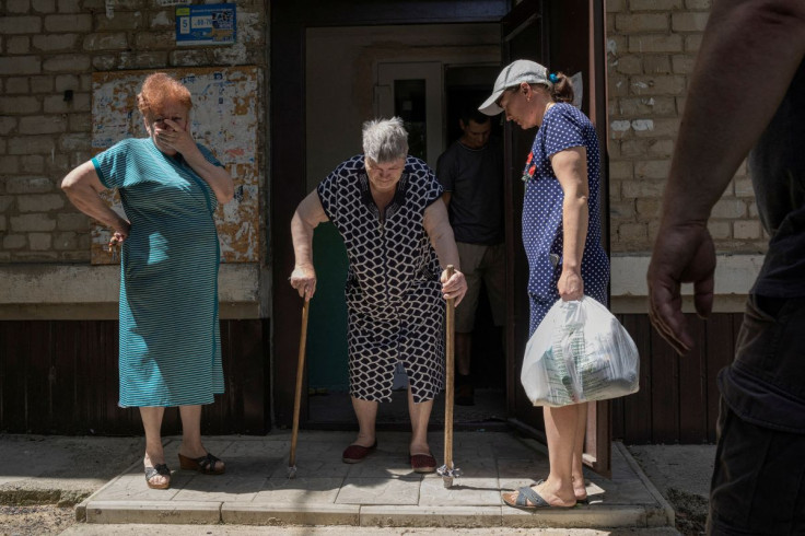 Eugenia Savchenko leaves her friend's house and is helped by volunteers from the organisation Vostok SOS during the evacuation of civilians from war-affected areas of eastern Ukraine, amid Russia's invasion of the country, in Bakhmut, Donetsk region, Ukra
