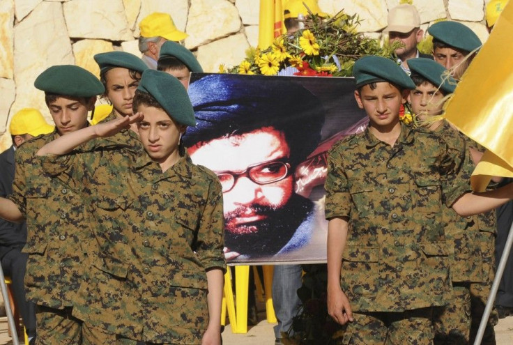 Supporters of Lebanon&#039;s Hezbollah listen to a televised address during a rally marking Resistance and Liberation Day in Nabi Sheet