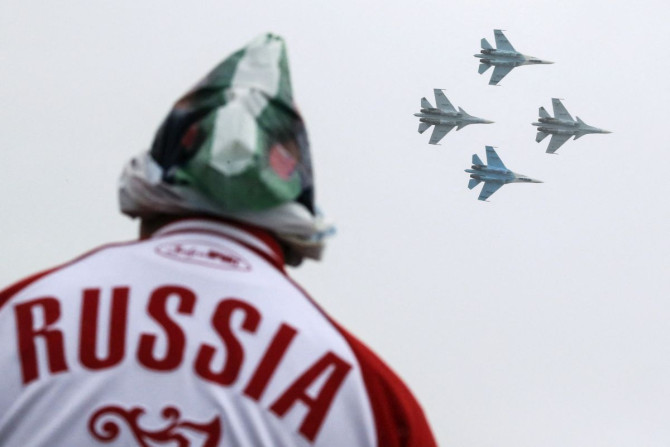 A spectator watches Sukhoi Su-30SM jet fighters of the Sokoly Rossii (Falcons of Russia) aerobatic team perform during the MAKS International Aviation and Space Salon in Zhukovsky, outside Moscow, Russia, August 29, 2015. 